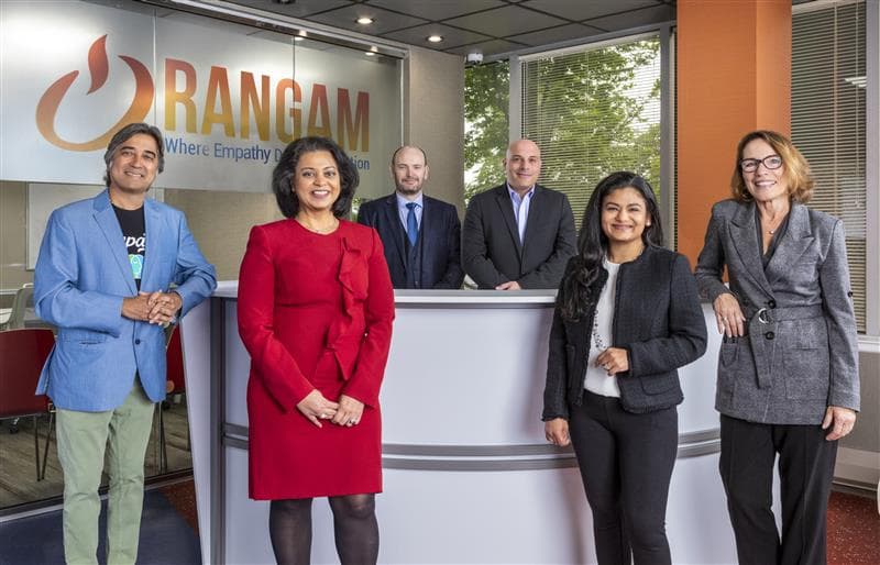 Six professionals standing at a reception desk with the Rangam logo behind them.